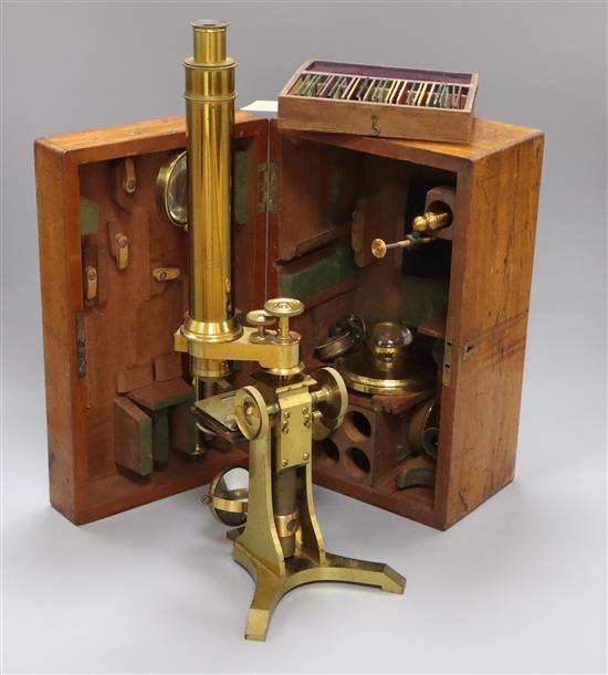 A Victorian brass scientific microscope by Ross, London, boxed with a case of slides